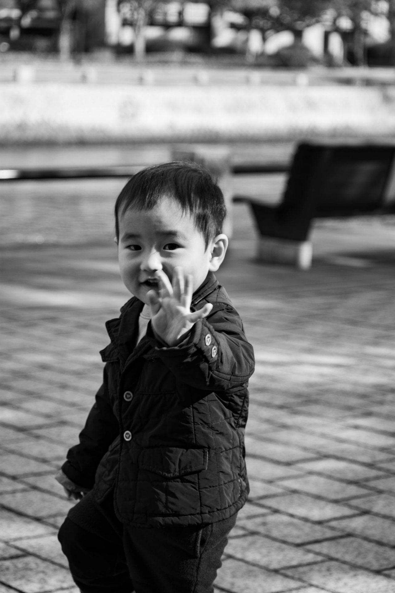 Young kid waving to the camera while photographing