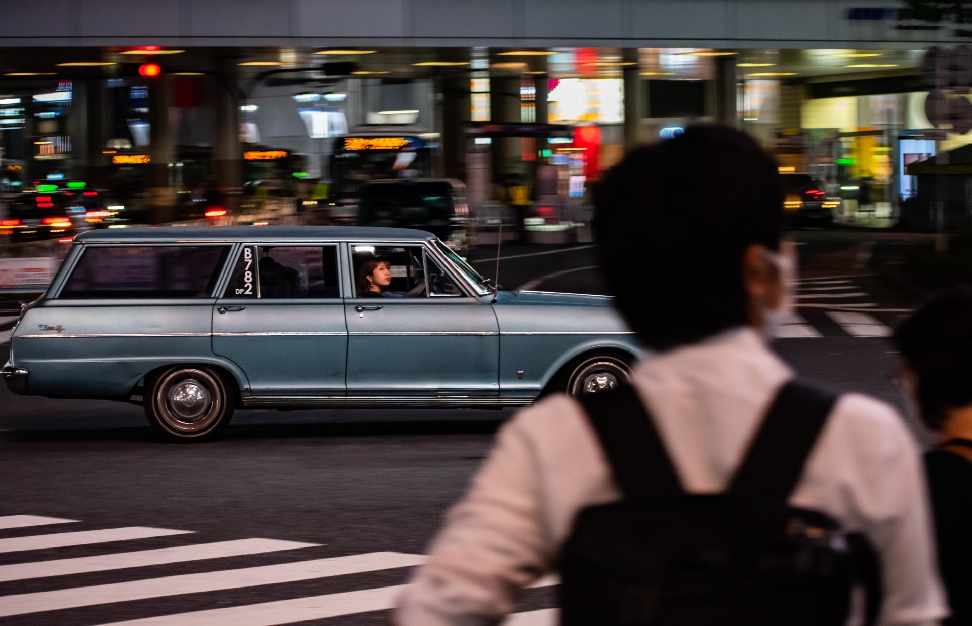 A lady looking out and up from a passing by car at shibuya crossing, Tokyo