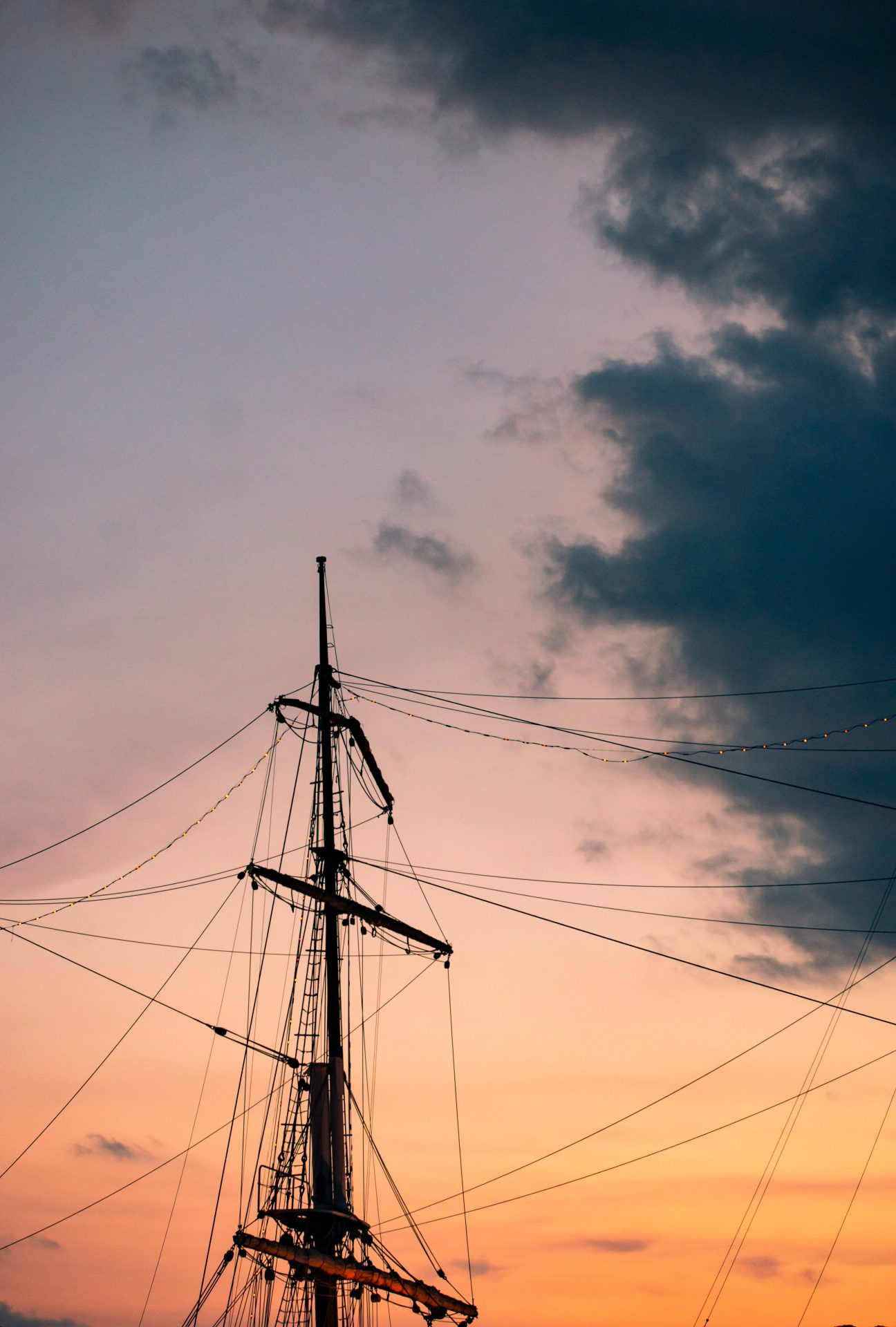 Top of old sailing boats in the sunset under stormy clouds